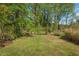 An expansive, lush backyard with mature trees and a charming fire pit for outdoor gatherings at 1804 N Alston Ave, Durham, NC 27701