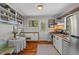Well-lit kitchen featuring white cabinets, open shelving, and hardwood floors, blending functionality with a touch of rustic charm at 1804 N Alston Ave, Durham, NC 27701