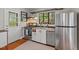 Efficient kitchen featuring stainless steel appliances, white cabinets, hardwood floors, and a bright window for natural light and scenic views at 1804 N Alston Ave, Durham, NC 27701