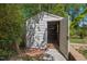 Quaint white shed with open door, showcasing brick foundation, offering potential for storage or workshop at 1804 N Alston Ave, Durham, NC 27701