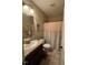 Cozy bathroom featuring a vanity, toilet, and shower with a button-adorned curtain at 194 Wood Valley Dr, Four Oaks, NC 27524