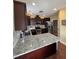 Well-lit kitchen with stainless steel appliances, ample counter space, and dark wood cabinets at 194 Wood Valley Dr, Four Oaks, NC 27524