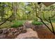 Beautiful backyard featuring stone retaining walls, garden path, and lush greenery for a serene outdoor space at 195 Nicks W Bnd, Pittsboro, NC 27312