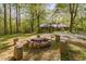 Charming fire pit area surrounded by stone seating, nestled in a serene wooded backyard at 195 Nicks W Bnd, Pittsboro, NC 27312