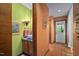 Well-lit bathroom with bright green walls featuring wood cabinets and a hall leading to front door at 195 Nicks W Bnd, Pittsboro, NC 27312