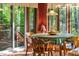 Sunlit dining area with a table and chairs, surrounded by large windows with nature views at 195 Nicks W Bnd, Pittsboro, NC 27312