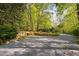 Exterior of the home with gravel parking and lush natural landscaping at 195 Nicks W Bnd, Pittsboro, NC 27312
