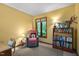 Cozy sitting room area with natural light, comfortable chair, and bookshelves at 195 Nicks W Bnd, Pittsboro, NC 27312