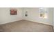 Empty bedroom featuring neutral walls and carpet with two windows and wall art at 2009 Mallard Ln, Raleigh, NC 27609