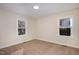 Bedroom with neutral carpet and walls, featuring two windows with natural light at 2009 Mallard Ln, Raleigh, NC 27609