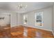 Bright living room featuring hardwood floors, two large windows, and modern light fixture at 2009 Mallard Ln, Raleigh, NC 27609