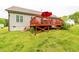 Well-maintained backyard features a spacious lawn, a red deck, and mature landscaping at 201 Lexington Park Dr, Oxford, NC 27565