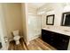 Bathroom featuring a shower, double sink vanity, dark wood cabinetry, and wood-style flooring at 201 Lexington Park Dr, Oxford, NC 27565