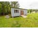 Outdoor shed with double doors and a ramp in a green grassy backyard at 201 Lexington Park Dr, Oxford, NC 27565