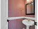 Striking half-bathroom featuring a pedestal sink and red and white striped wallpaper at 201 Wendy Pl, Benson, NC 27504