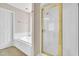 Well-lit bathroom featuring a white tub, shower with gold trim, and neutral tones at 201 Wendy Pl, Benson, NC 27504