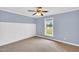 Cozy bedroom with carpet, wainscoting, a ceiling fan, and a large window at 201 Wendy Pl, Benson, NC 27504