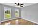 Bright bedroom with hardwood floors, two windows, and a modern ceiling fan at 201 Wendy Pl, Benson, NC 27504