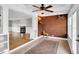 Open sunroom with brick accent wall, ceiling fan, and access to living area at 201 Wendy Pl, Benson, NC 27504