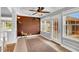 Bright sunroom with tile flooring, exposed brick, ceiling fan, and natural light at 201 Wendy Pl, Benson, NC 27504