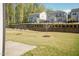 Spacious backyard featuring a well-maintained lawn, tree, and retaining wall for added visual appeal at 2221 Holtwood Way, Apex, NC 27523