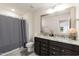 Bathroom featuring granite double vanity, framed mirror, and bath/shower with gray shower curtain at 2221 Holtwood Way, Apex, NC 27523