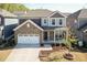 Charming two-story home with stone accents, a two-car garage, and a beautifully landscaped front yard at 2221 Holtwood Way, Apex, NC 27523