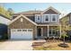 Charming two-story home with stone accents, a two-car garage, and a beautifully landscaped front yard at 2221 Holtwood Way, Apex, NC 27523