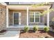 Charming brick home entrance featuring a covered porch and a black front door with white trim at 2221 Holtwood Way, Apex, NC 27523