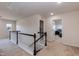 Upstairs hallway with white railing, carpet, and access to bedrooms and attic at 2221 Holtwood Way, Apex, NC 27523