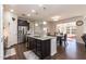 Open kitchen featuring a granite island, stainless steel appliances, and a seamless transition to the dining area at 2221 Holtwood Way, Apex, NC 27523