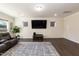 Living room with modern entertainment center, plush leather seating, and windows offering natural light at 2221 Holtwood Way, Apex, NC 27523