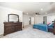 An open main bedroom that features carpeted floors, neutral-toned walls, a ceiling fan and a large dark wood dresser at 2221 Holtwood Way, Apex, NC 27523