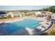 Large community pool with lounge chairs and tables surrounded by single Gathering homes at 2221 Holtwood Way, Apex, NC 27523