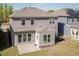 Back of home featuring gray siding, windows, and a patio leading to a grassy yard at 2221 Holtwood Way, Apex, NC 27523