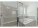 A bathroom with a glass shower, soaking tub, and neutral-toned tile work at 2227 Rocky Bay Ct, Cary, NC 27519
