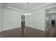 Spacious dining room showcasing hardwood floors, elegant chandelier, wainscoting, and neutral wall color at 2227 Rocky Bay Ct, Cary, NC 27519