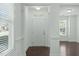 Bright foyer featuring hardwood floors, white trim, transom window above the front door, and natural light at 2227 Rocky Bay Ct, Cary, NC 27519