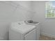 Bright laundry room features a washer, dryer, storage shelf, and a window for natural light at 2227 Rocky Bay Ct, Cary, NC 27519