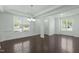 Open-concept living and dining area with hardwood floors, modern lighting, and large windows for ample natural light at 2227 Rocky Bay Ct, Cary, NC 27519