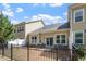 Spacious backyard with a patio for entertaining, surrounded by a classic black fence at 225 Mayfield Dr, Apex, NC 27539
