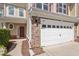 Close up of the home's entrance and two car garage with stone and siding details at 225 Mayfield Dr, Apex, NC 27539