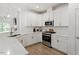 Well lit kitchen featuring modern appliances, white cabinetry, and quartz countertops at 225 Mayfield Dr, Apex, NC 27539