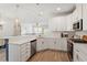 Bright kitchen features stainless steel appliances, quartz countertops, and stylish pendant lighting at 225 Mayfield Dr, Apex, NC 27539