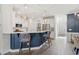 Open concept kitchen with stylish pendant lights, counter seating, and views to the laundry room at 225 Mayfield Dr, Apex, NC 27539