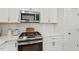 Kitchen close-up showcasing stainless steel oven, microwave and stylish white cabinetry at 225 Mayfield Dr, Apex, NC 27539