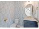 Stylish powder room features designer wallpaper, a round mirror, and a modern vanity at 225 Mayfield Dr, Apex, NC 27539
