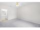 Spacious bedroom with a ceiling fan and an open doorway to an adjoining bathroom with white vanity at 2421 Kudrow Ln, Morrisville, NC 27560