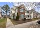 Inviting townhome exterior with brick accents, green shutters, well-maintained landscaping, and sidewalk access at 2421 Kudrow Ln, Morrisville, NC 27560