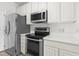Modern kitchen featuring stainless steel appliances, white cabinets, and quartz countertops at 2421 Kudrow Ln, Morrisville, NC 27560